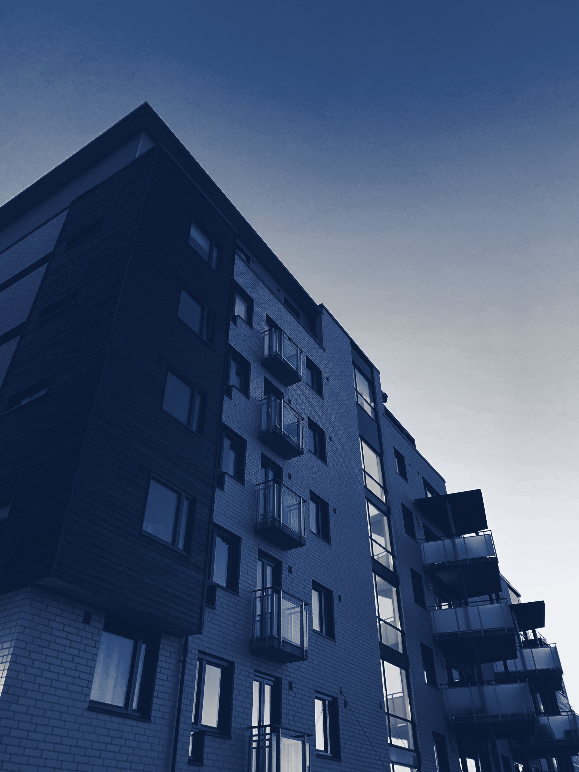 Apartment building seen from below, tinted navy