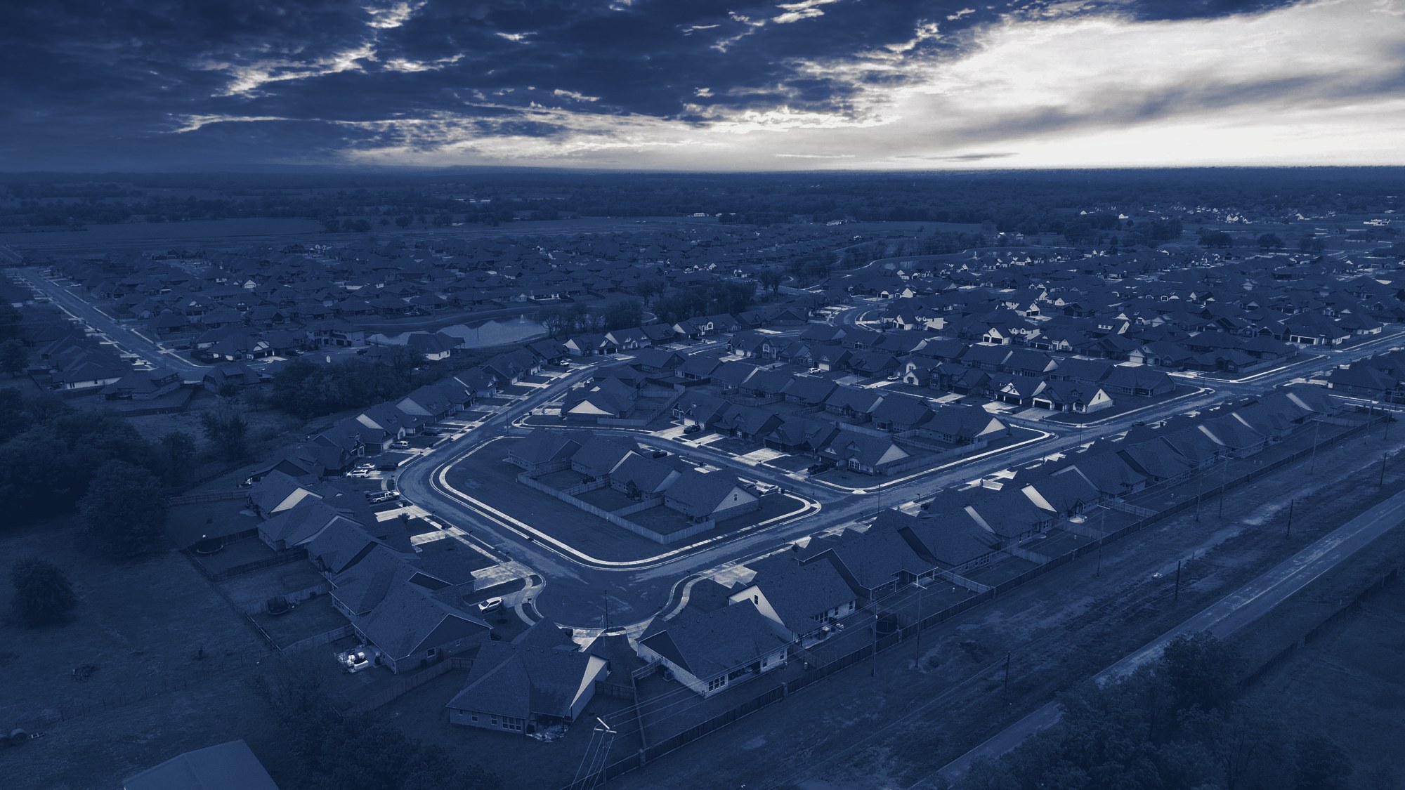 Aerial view of a neighborhood at sunset, tinted navy